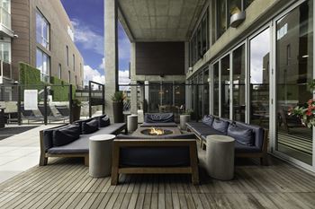 A patio with couches and a fire pit in the middle of a building